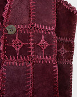 This burgundy leather vest is a vintage gem from the 80s, featuring unique stitching flowers and a boho-style cut. With no closure, it's perfect for layering over any outfit!