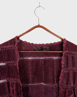 This burgundy leather vest is a vintage gem from the 80s, featuring unique stitching flowers and a boho-style cut. With no closure, it's perfect for layering over any outfit!