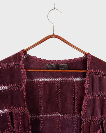 This burgundy leather vest is a vintage gem from the 80s, featuring unique stitching flowers and a boho-style cut. With no closure, it's perfect for layering over any outfit!