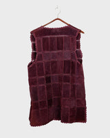 This burgundy leather vest is a vintage gem from the 80s, featuring unique stitching flowers and a boho-style cut. With no closure, it's perfect for layering over any outfit!