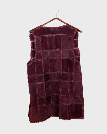 This burgundy leather vest is a vintage gem from the 80s, featuring unique stitching flowers and a boho-style cut. With no closure, it's perfect for layering over any outfit!