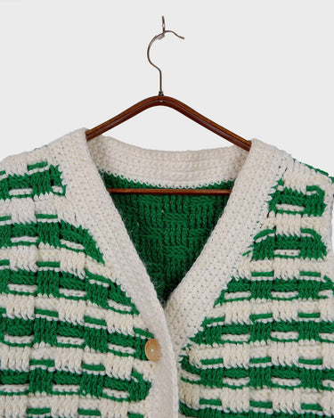 This handmade knit vest in rich green and cream tones is a true eye-catcher. Crafted from wool blend yarn and finished with natural wooden buttons, it blends cozy texture with bold design. The chunky crochet style and timeless check pattern make it perfect for layering.