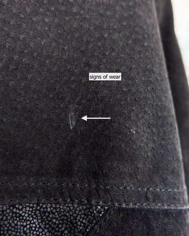 This vintage black leather coat blends matte suede leather with subtly glossy smooth leather panels in rich black tones. The unique patchwork design, featuring delicate dot-textured sections, adds depth, texture, and quiet individuality. With its sleek cut, button front, and spacious pockets, this timeless piece is full of character – perfect for those who appreciate quality and one-of-a-kind style.