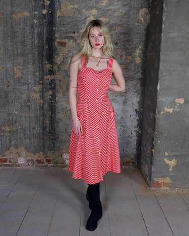 Get ready to add some fun to your wardrobe with this Vintage 80s red yellow striped a-form dress! This playful dress features bold stripes in bright colors, short sleeves, and button detailing.