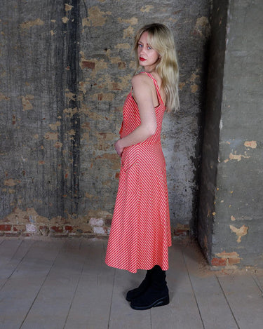 Get ready to add some fun to your wardrobe with this Vintage 80s red yellow striped a-form dress! This playful dress features bold stripes in bright colors, short sleeves, and button detailing.