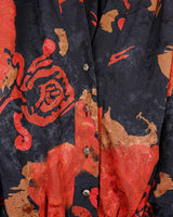 This vintage 80s velvet x silk blouse is having a moment! Its flowy and lightweight transparent fabric, coupled with its stunning red floral pattern, make it a must-have!