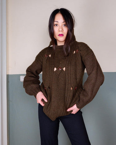 This Vintage 90s brown wool sweater is sure to make a statement with its unique cut outs. Made from high-quality wool, it's perfect for staying cozy while still showing off some skin.