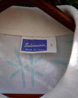 Sun’s out, button up! This Italian vintage white polo shirt brings serious 80s energy with its sharp button-up neckline and eye-catching turquoise pattern. A rare vintage gem that’s equal parts sporty, stylish, and a little cheeky. Wear it loud, wear it proud – this polo’s got main character energy.