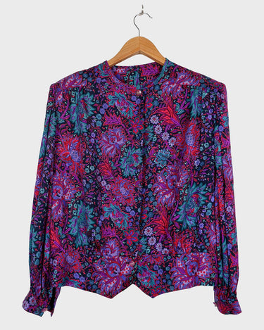 Lookin' for a way to make some '80s style magic? Slip on this vintage purple floral blouse with light shimmering accents and shoulder pads for a look that sparkles!