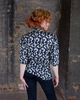 Get ready to channel some serious 90s romance with this vintage navy blue floral blouse with its light shimmering optic. Crafted from a luxurious silk mix blend, it features golden buttons and a unique collar for some extra flair. Romance never goes out of style!
