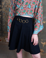 This vintage 90s mini skirt with bold gold ring details is a true statement piece with attitude. Vintage, but made for now.