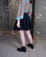 This vintage 90s mini skirt with bold gold ring details is a true statement piece with attitude. Vintage, but made for now.