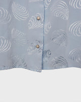 Introduce some sparkle to your style with this vintage 80s light blue blouse. The flattering fit, courtesy of the short sleeves and shoulder pads, meets a playful touch of shimmering pattern. Sparkle on!