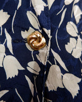Get ready to channel some serious 90s romance with this vintage navy blue floral blouse with its light shimmering optic. Crafted from a luxurious silk mix blend, it features golden buttons and a unique collar for some extra flair. Romance never goes out of style!
