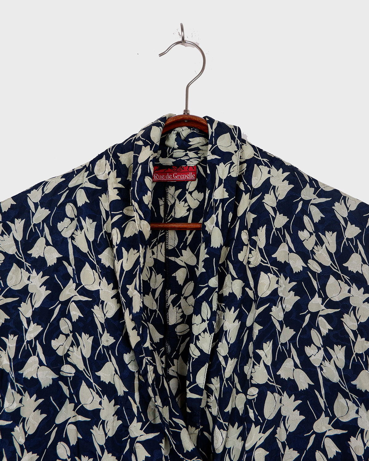 Get ready to channel some serious 90s romance with this vintage navy blue floral blouse with its light shimmering optic. Crafted from a luxurious silk mix blend, it features golden buttons and a unique collar for some extra flair. Romance never goes out of style!