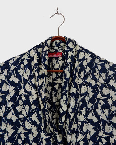 Get ready to channel some serious 90s romance with this vintage navy blue floral blouse with its light shimmering optic. Crafted from a luxurious silk mix blend, it features golden buttons and a unique collar for some extra flair. Romance never goes out of style!