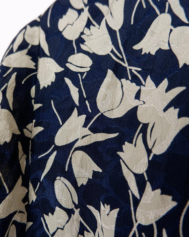 Get ready to channel some serious 90s romance with this vintage navy blue floral blouse with its light shimmering optic. Crafted from a luxurious silk mix blend, it features golden buttons and a unique collar for some extra flair. Romance never goes out of style!