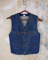 This vintage denim vest is tough, timeless, and ready to layer. It features classic brass snap buttons and four front pockets for that old-school workwear vibe.