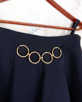 This vintage 90s mini skirt with bold gold ring details is a true statement piece with attitude. Vintage, but made for now.