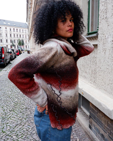 This retro turtleneck takes you on a wild ride of hot reds, cool whites, and mellow browns for a preloved color combo.