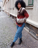 This retro turtleneck takes you on a wild ride of hot reds, cool whites, and mellow browns for a preloved color combo.