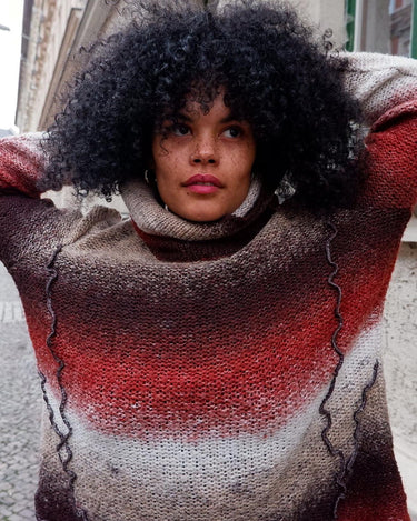 This retro turtleneck takes you on a wild ride of hot reds, cool whites, and mellow browns for a preloved color combo.