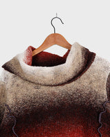 This retro turtleneck takes you on a wild ride of hot reds, cool whites, and mellow browns for a preloved color combo.