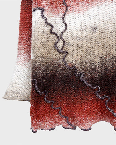 This retro turtleneck takes you on a wild ride of hot reds, cool whites, and mellow browns for a preloved color combo.