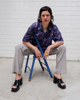 Bold, breezy, and silky smooth - this rare 90s short-sleeve gem by T. Corner is made from real Thai silk, brought to you by one of Thailand’s most renowned silk producers. The glossy fabric pops with a crazy pattern in electric purples and blues that’s impossible to ignore. Wear it loud, wear it proud
