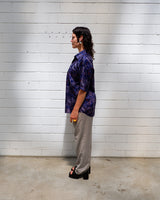 Bold, breezy, and silky smooth - this rare 90s short-sleeve gem by T. Corner is made from real Thai silk, brought to you by one of Thailand’s most renowned silk producers. The glossy fabric pops with a crazy pattern in electric purples and blues that’s impossible to ignore. Wear it loud, wear it proud
