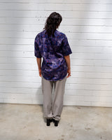 Bold, breezy, and silky smooth - this rare 90s short-sleeve gem by T. Corner is made from real Thai silk, brought to you by one of Thailand’s most renowned silk producers. The glossy fabric pops with a crazy pattern in electric purples and blues that’s impossible to ignore. Wear it loud, wear it proud