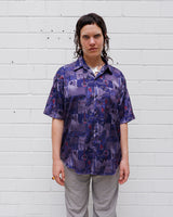 Bold, breezy, and silky smooth - this rare 90s short-sleeve gem by T. Corner is made from real Thai silk, brought to you by one of Thailand’s most renowned silk producers. The glossy fabric pops with a crazy pattern in electric purples and blues that’s impossible to ignore. Wear it loud, wear it proud!