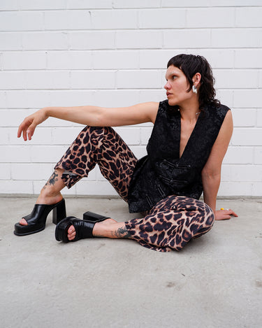 This Y2k black vest blends classic baroque style with a subtle gothic edge. The textured floral pattern and fleur-de-lis buttons give it a refined yet bold character. Cool, confident and a little unexpected – a standout piece without shouting.