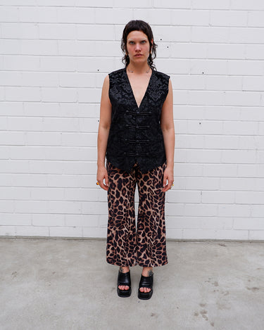 This Y2k black vest blends classic baroque style with a subtle gothic edge. The textured floral pattern and fleur-de-lis buttons give it a refined yet bold character. Cool, confident and a little unexpected – a standout piece without shouting.