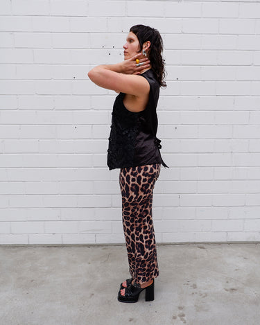 This Y2k black vest blends classic baroque style with a subtle gothic edge. The textured floral pattern and fleur-de-lis buttons give it a refined yet bold character. Cool, confident and a little unexpected – a standout piece without shouting.