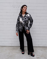 This black and white shirt doesn’t ask for attention — it just gets it. The abstract swirl pattern gives effortless chaos in the best way possible. Throw it on and let the print do the talking!