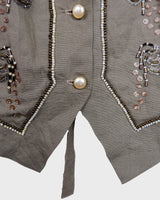 Fine beadwork and soft sequins give this 90s brown-grey waistcoat its understated shine – subtle, but impossible to miss. With a paisley satin back and belt, it’s a thoughtful piece for those who appreciate timeless style and fine detail.