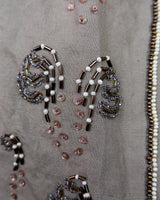 Fine beadwork and soft sequins give this 90s brown-grey waistcoat its understated shine – subtle, but impossible to miss. With a paisley satin back and belt, it’s a thoughtful piece for those who appreciate timeless style and fine detail.
