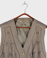 Fine beadwork and soft sequins give this 90s brown-grey waistcoat its understated shine – subtle, but impossible to miss. With a paisley satin back and belt, it’s a thoughtful piece for those who appreciate timeless style and fine detail.