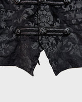 This Y2k black vest blends classic baroque style with a subtle gothic edge. The textured floral pattern and fleur-de-lis buttons give it a refined yet bold character. Cool, confident and a little unexpected – a standout piece without shouting.