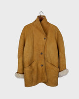 Cozy up in this vintage 80s shearling coat, perfect for chilly days. Its rich brown and mustard yellow colors add a bold touch, while the shearling material provides warmth and comfort. A must-have piece for your wardrobe, this coat is a timeless addition that will never go out of style.