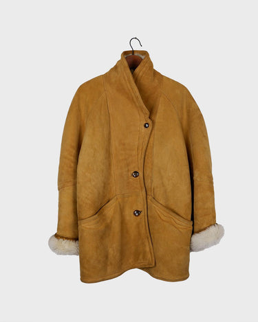 Cozy up in this vintage 80s shearling coat, perfect for chilly days. Its rich brown and mustard yellow colors add a bold touch, while the shearling material provides warmth and comfort. A must-have piece for your wardrobe, this coat is a timeless addition that will never go out of style.