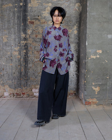 1980s vintage silk blouse with a loose fit and floral print in burgundy-violet on taupe. The silk adds a natural sense of luxury and ease. A laid-back piece with quiet elegance and vintage character.