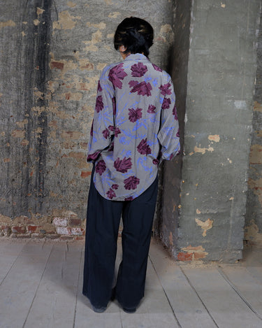 1980s vintage silk blouse with a loose fit and floral print in burgundy-violet on taupe. The silk adds a natural sense of luxury and ease. A laid-back piece with quiet elegance and vintage character.