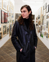 This vintage 90s black long leather belted (optional belt!) coat is your ticket to a timeless look!
