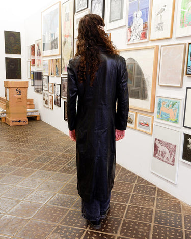 This vintage 90s black long leather belted (optional belt!) coat is your ticket to a timeless look!