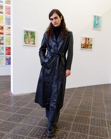 This vintage 90s black long leather belted (optional belt!) coat is your ticket to a timeless look!