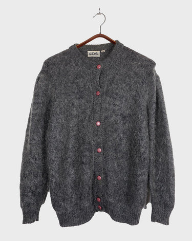 Get your hands on this amazing Vintage 80s grey mohair mix cardigan! It comes with fun pink buttons that add a touch of playfulness to your outfit. Perfect for layering and adding a pop of color to your look.