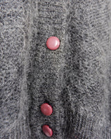 Get your hands on this amazing Vintage 80s grey mohair mix cardigan! It comes with fun pink buttons that add a touch of playfulness to your outfit. Perfect for layering and adding a pop of color to your look.