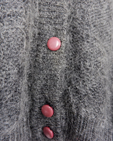 Get your hands on this amazing Vintage 80s grey mohair mix cardigan! It comes with fun pink buttons that add a touch of playfulness to your outfit. Perfect for layering and adding a pop of color to your look.